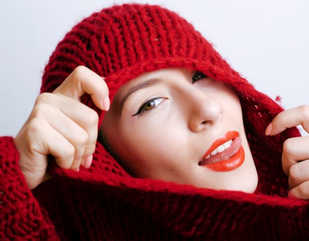 young pretty woman in sweater and scarf all over her face at winterの写真素材