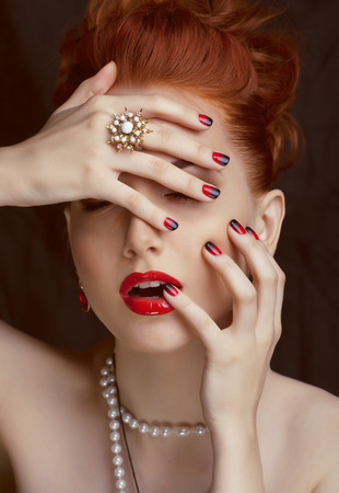beauty stylish redhead woman with hairstyle and manicure wearing jewelryの写真素材