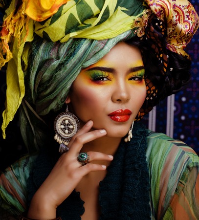 beauty bright woman with creative make up, many shawls on head like cubian, ethno lookの写真素材