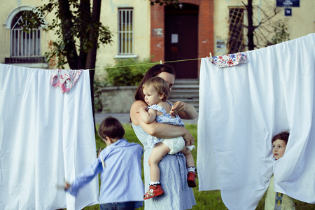 woman with children in garden hanging laundry outsideの写真素材