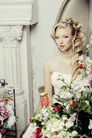 beauty young bride alone in luxury vintage interior with a lot of flowersの写真素材
