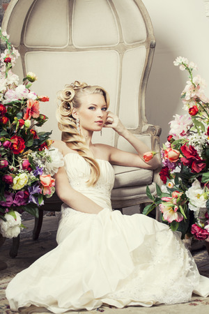 beauty young bride alone in luxury vintage interior with a lot of flowersの写真素材