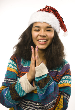 cute young girl in santas red hat isolated, waiting for Christmasの写真素材