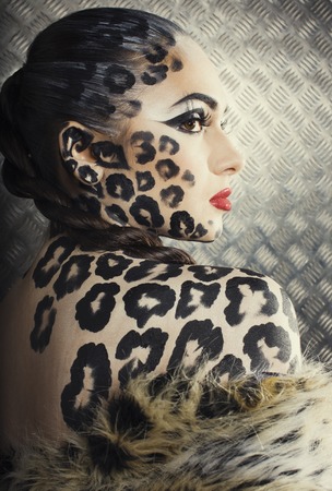 young sexy woman with leopard make up all over body, cat bodyart print closeupの写真素材