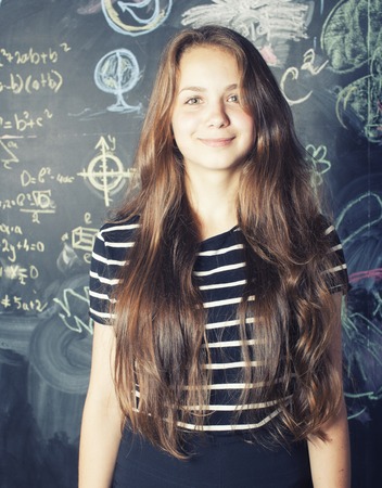 back to school after summer vacations, cute teen real girl in classroom smilingの写真素材