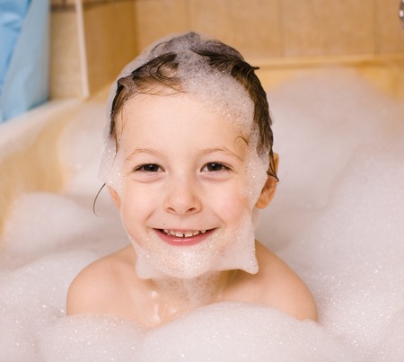 little cute boy in bathroom with bubbles close upの写真素材