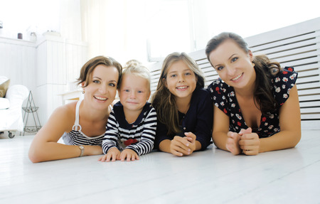 Mature sisters twins at home with little daughter, happy family smilingの写真素材