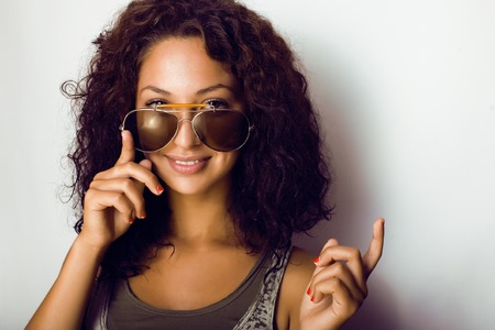 portrait of happy funny teenage girl with sunglasses isolatedの写真素材