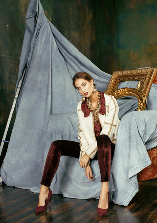 beauty rich brunette woman in luxury interior near empty frames, vintage eleganceの写真素材