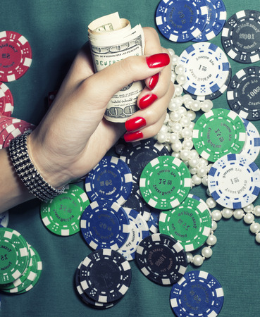 hands of young caucasian woman with blue manicure at casino table close up, deep indigo design on nailsの写真素材