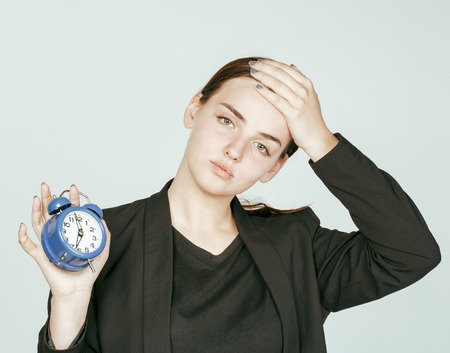 young beauty woman in business style costume waking up for work early morning on white backgroundの写真素材