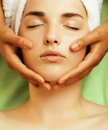 stock photo attractive lady getting spa treatment in salon, close up asian tan hands on faceの写真素材