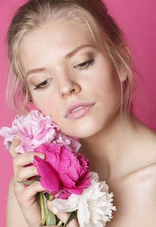young beauty woman with flower peony pink closeup makeup soft tender gentle look on whiteの写真素材