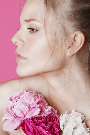young beauty woman with flower peony pink closeup makeup soft tender gentle look on whiteの写真素材