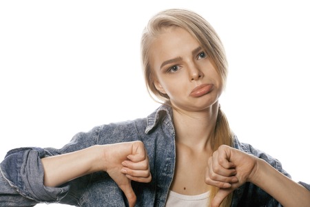 young blond woman on white backgroung gesture thumbs up, isolatedの写真素材