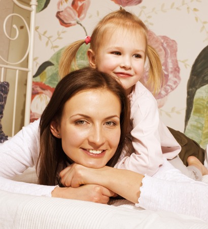 young mother with daughter at home playing, happy familyの写真素材