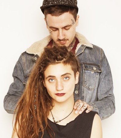 young couple together. guy with tattoo, girlfriend wearing dreadlocks having fun
