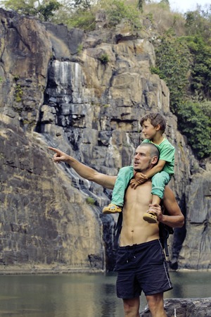 father and son making a trip to waterfall together, happy family on vacations, nature place pongourの写真素材