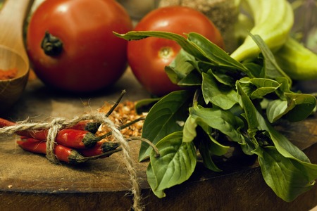 vegetables on wooden kitchen with spicies, tomato, chilli, green beans, garlic close up blurred backgroundの写真素材
