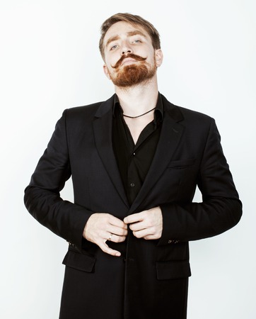young red hair man with beard and mustache in black suit on white background close upの写真素材