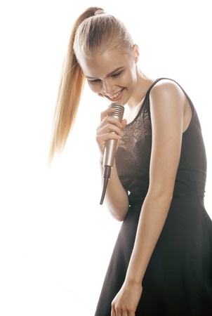 young pretty blond woman singing in microphone isolated close upの写真素材