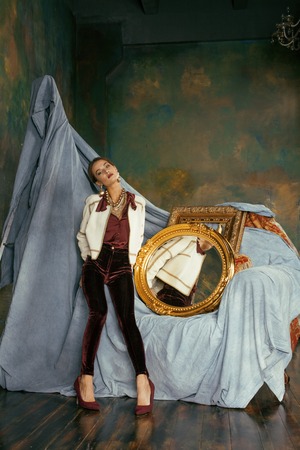 beauty rich brunette woman in luxury interior near empty frames, vintage elegance close upの写真素材