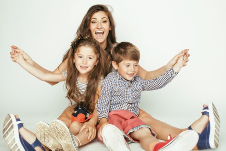 young mother with two children on white, happy smiling family insideの写真素材