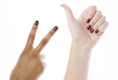 two different nathion manicured hands on white isolated, african with caucasianの写真素材