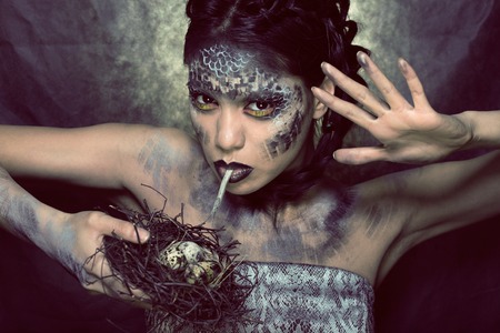 fashion portrait of pretty young woman with creative make up like a snake halloweenの写真素材