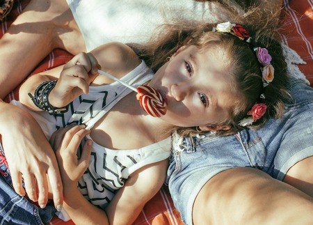 cute happy family on picnic laying on green grass mother and kids, warm summer vacations close upの写真素材