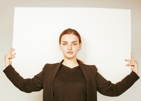 young pretty brunette girl with placard on white background wearing business costume student