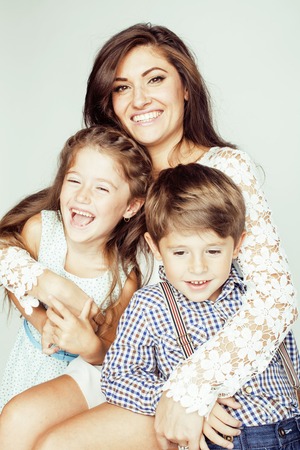 young mother with two children on white, happy smiling family inside close upの写真素材