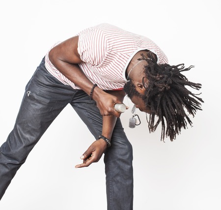 young handsome african american boy singing emotional with microphone isolated on white background,...