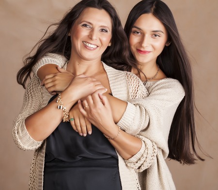cute pretty teen daughter with mature mother huggingの写真素材
