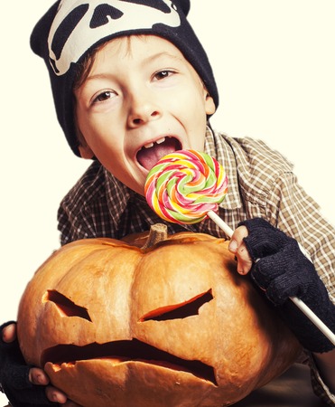 little cute boy with halloween pumpkin close up holding candy isolated, trick or treatの写真素材