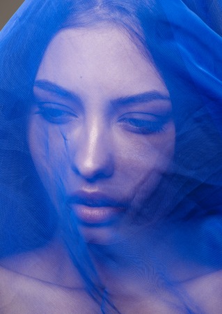 beauty young islamic woman under veil, blue hijab on face close up, art terrorismの写真素材