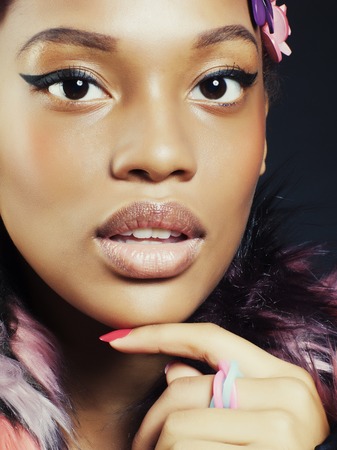 young pretty african american woman in spotted fur coat and flowers jewelry on head smiling sweet etnic girlの写真素材
