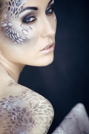 fashion portrait of pretty young woman with creative make up like a snake, fashion victim  python skin clutch luxury lookの写真素材