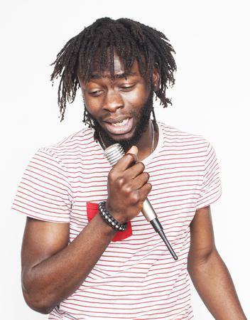 young handsome african american boy singing emotional with microphone isolated on white background, in motion gesturing smiling close up. karaoke singerの写真素材