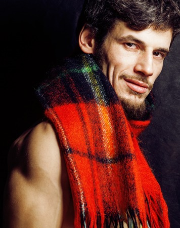 portrait of handsome man warmed up in scarf, smiling closeup dark background, brutal winter guyの写真素材