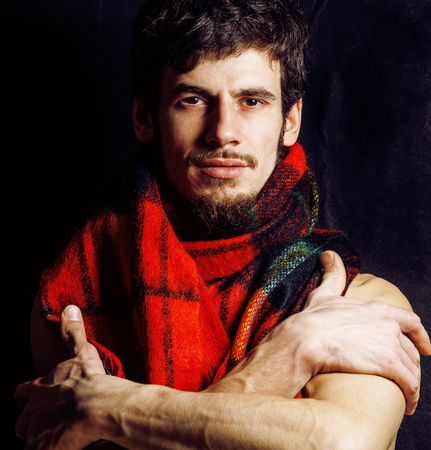 portrait of handsome man warmed up in scarf, smiling closeup dark background, winter guyの写真素材