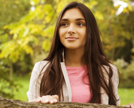 young pretty brunette girl in park smilingの写真素材
