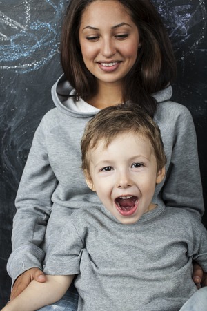 young hipster teenage girl sitting with her brother in classroom multinational, diverse familyの写真素材