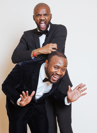 two afro-american businessmen in black suits emotional posing, gesturing, smiling. wearing bow-ties entertainmentの写真素材
