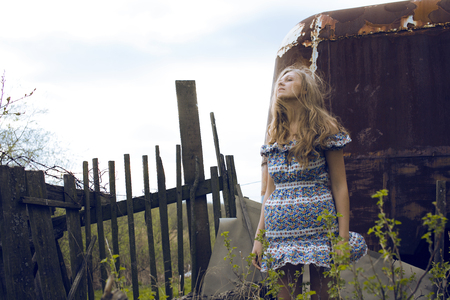 young pretty girl in hippy dress at her house countryside, hair in mess becouse of windの写真素材