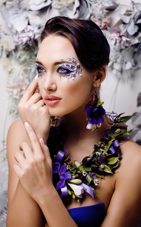 floral face art with anemone in jewelry, sensual young brunette woman in studio close up, 8 march conceptの写真素材