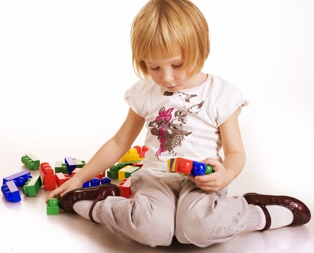 portrait of little cute girl painting and playing lego, fooling around, isolated on white backgroundの写真素材