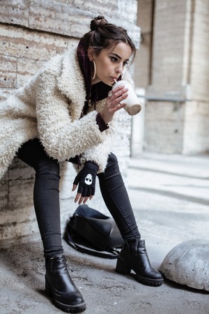 young pretty stylish teenage girl outside on city street fancy fashion dressed drinking milk shake...