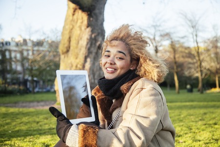 young cute blond african american girl student holding tablet and smiling, lifestyle people concept,...