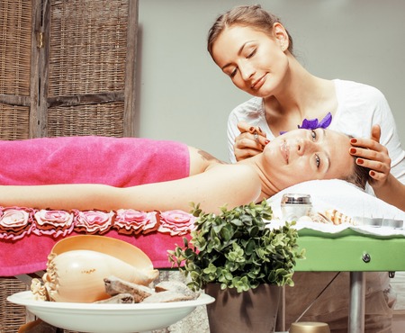 stock photo attractive lady getting spa treatment in salon, massage doctor smiling care pretty, beauty red manicureの写真素材
